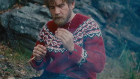 Man Eating Cooked Meat from Stick during Solo Survival Trip in Nature Stock Footage 317340109