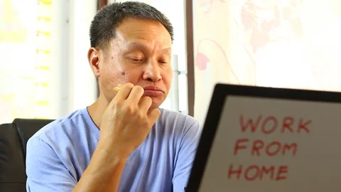 Man eating  cookie  and working with laptop at home, in  door  Chiangmai Thailan Stock Footage 152703034