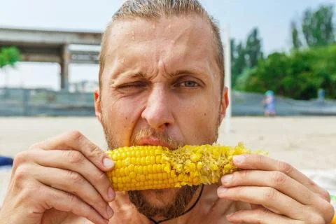 Man is eating corn Stock Photos