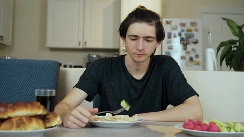 Man eating cucumber slice with fork Stock Footage 328370683