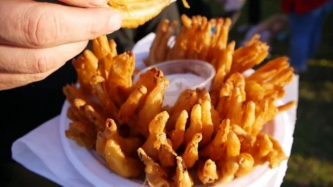 Man eating deep fried blooming onion dipping in ranch sauce Stock Footage