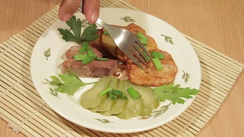 Man eating dish of potatoes with roasted meat Stock Footage 70926012