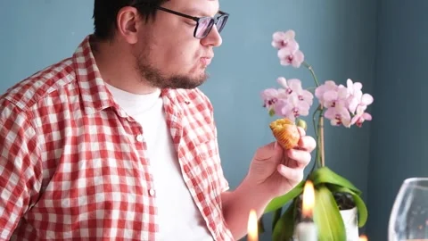 Man eating Easter cake and drinking coffee on dinner table Stock Footage 303635168