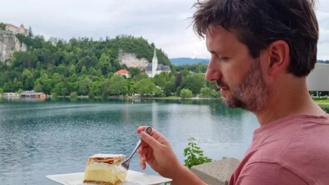 Man eating the famous Bled cake on a terrace in Bled in Slovenia, Europe Stock Footage 199965503