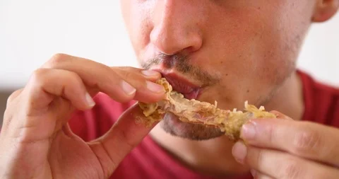 Man eating fast food meat chicken wings unhealthy lifestyle bad diet habits Stock Footage