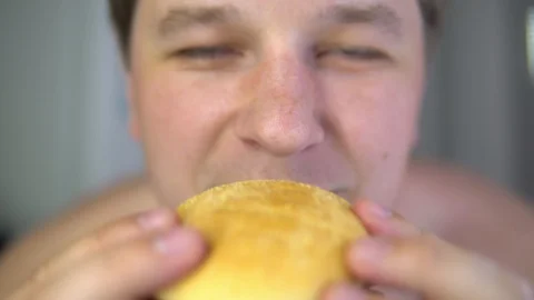 The man is eating a hamburger. Close-up. Stock Footage 89889192