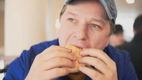 The man is eating a hamburger Stock Footage 87665246