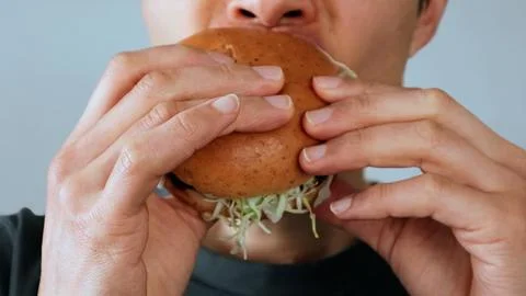A man eating a hamburger Stock Photos