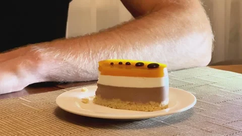 Man Eating Layered Mousse Cake Slice With Fork at Table Stock Footage 346010678