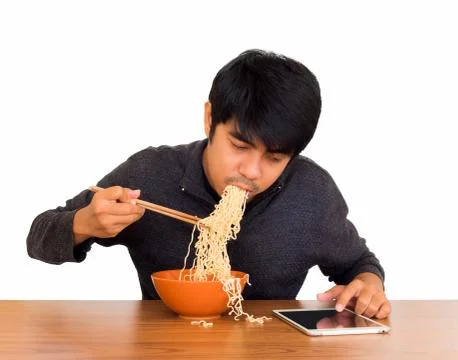 Man eating noodle and using tablet isolate. Stock Photos