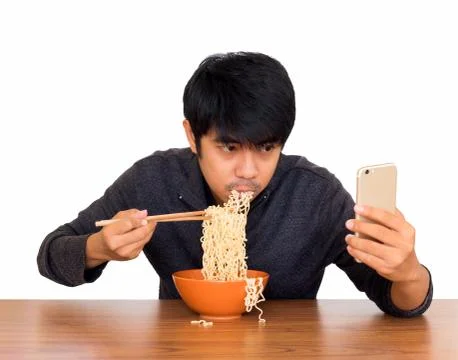 Man eating noodle and using smartphone isolate Stock Photos