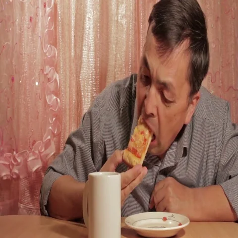 Man eating pie at home Stock Footage 69723558