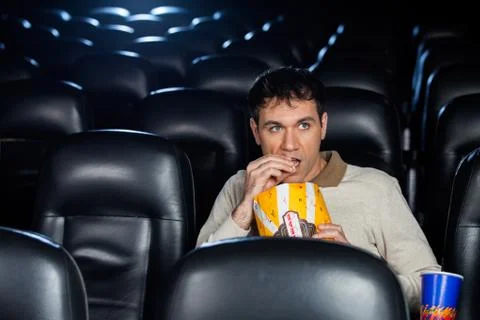 Man Eating Popcorn While Watching Movie In Theater Stock Photos