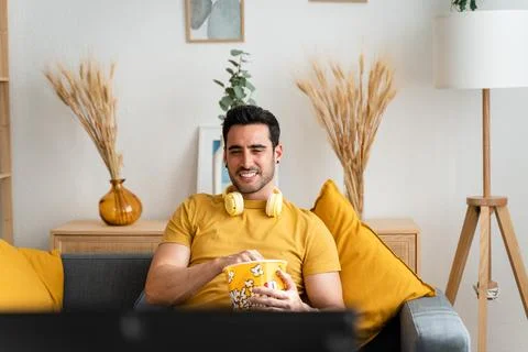 Man eating popcorn while watching tv. Stock Photos