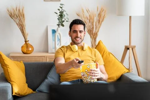 Man eating popcorn while watching tv. Stock Photos