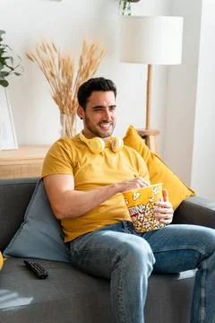 Man eating popcorn while watching tv. Stock Photos