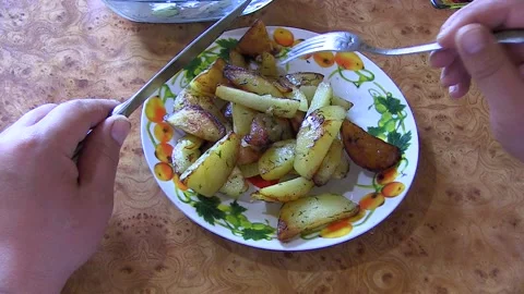 A man is eating a potato dish. Fork in the plate Stock Footage 106451218
