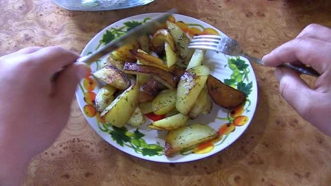 A man is eating a potato dish. Fork in the plate Stock Footage 106451292