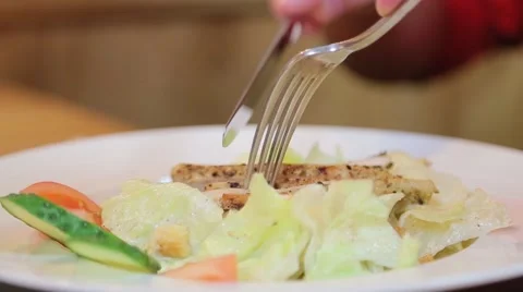 Man eating a salad with fork and knife Stock Footage 61157357