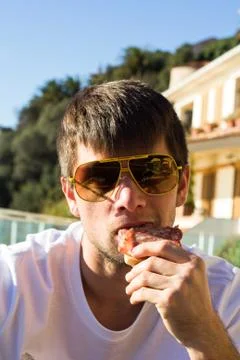 Man eating a salami bread for breakfast Stock Photos