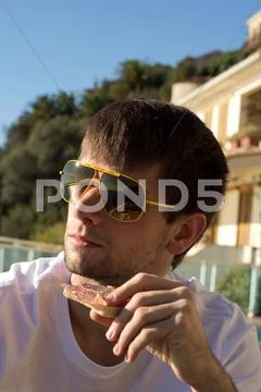 Man eating a salami bread for breakfast Stock Photos