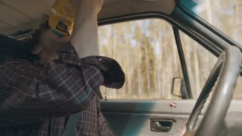 Man eating snacks while carelessly driving and crashes Stock Footage 83223042