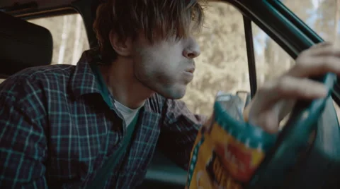 Man eating snacks while driving and crashes Stock Footage 63333132