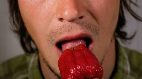Man eats appetizing ripe strawberries close-up. Hungry guy chews a large ripe Stock Footage 91270750