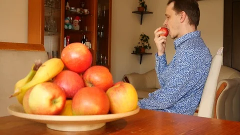 A Man eats an Apple at Home, healthy vegetarian Food Stock Footage 124650226