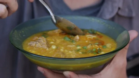 Man eats Argentinean locro with a spoon 스톡 동영상 123799758