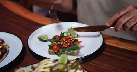 A Man Eats Avocado Toast With Cutlery, Enjoying the Flavors and Textures. Stockbeeldmateriaal 286430184