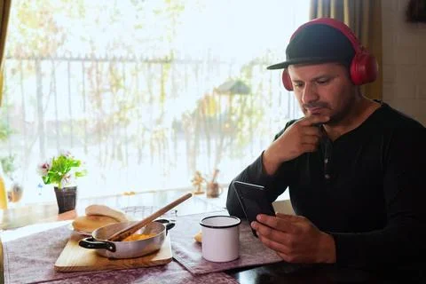 Man eats breakfast and checks his cell phone Stock Photos