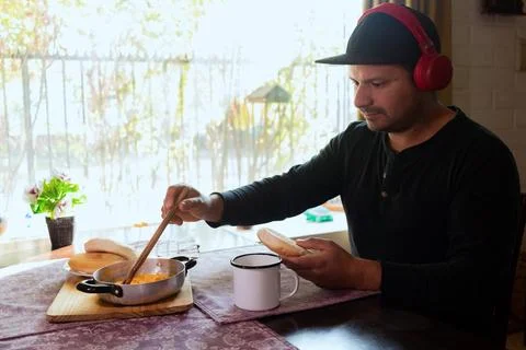 Man eats breakfast while listening to music Stock Photos