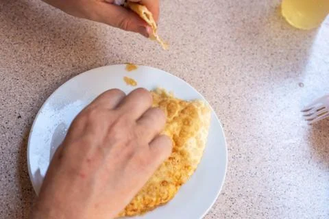 A man eats a cheburek with meat on a plate. Public food. selective focus Stock Photos