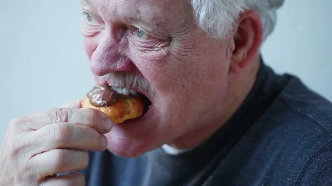 Man eats chocolate-covered croissant Stock Footage 89347531