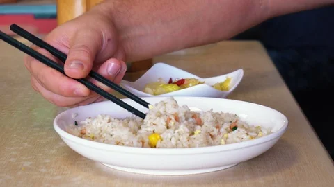 A man eats chopsticks rice with vegetables. Close-up Stock Footage 100907996