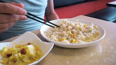 A man eats chopsticks rice with vegetables. Close-up Video stock 100909102