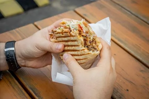 A man eats Doner Kebab at a local street food stall Stock Photos