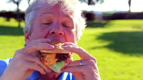 MAN EATS DOUBLE CHEESEBURGER Stock Footage 948054