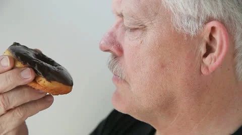Man eats doughnut glazed with chocolate Stock Footage 22675224