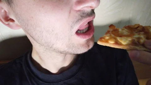 Man eats fast food biting pizza slice extreme close up Stock Footage 116118055