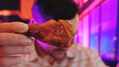 Man eats, fast food, chicken nuggets, wings and french fries interior background Stock Footage 101915186