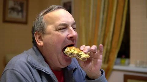 The man eats a hamburger and drinks soda. Man with hamburger at home. Foto stock