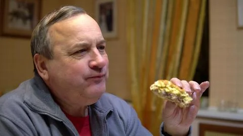 The man eats a hamburger and drinks soda. Man with hamburger at home. Stock Photos