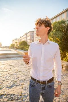 A man eats an ice cream while downtown during summertime Stock Photos