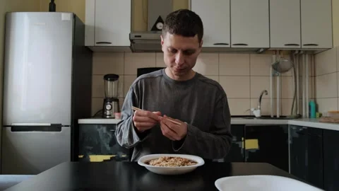 Man eats instant noodles at home. 库存影片 316407620