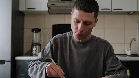Man eats instant noodles at home. Stock Footage 316408115