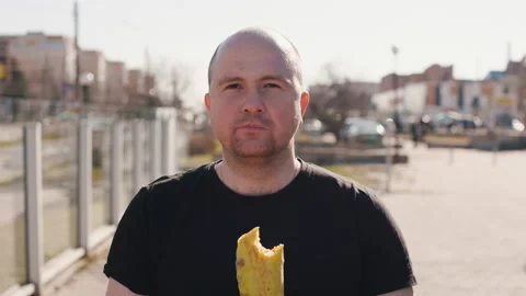 A Man eats Kebab on a City Street. Hungry Person in Black T-shirt taking with Stock Footage 234504255