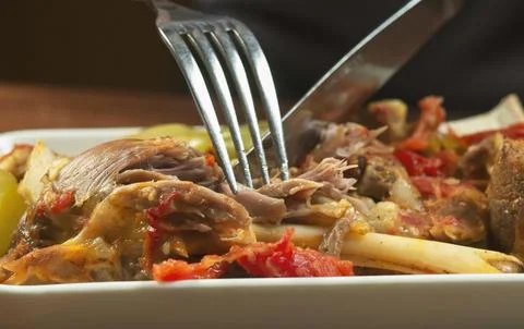 Man eats lamb stew on the bone with vegetables. Khashlama is popular Armenian Stock Photos