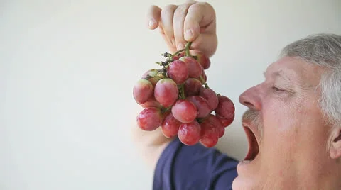Man eats large grapes Stock Footage 22675942
